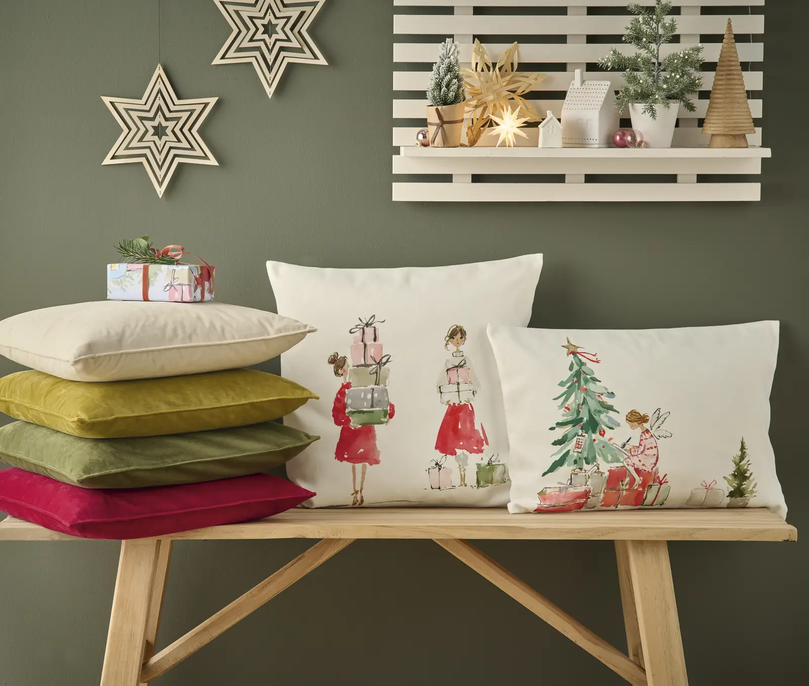 Zwei Kissen mit Damen und Geschenken bzw. Engel am Tannenbaum auf einer Holzbank